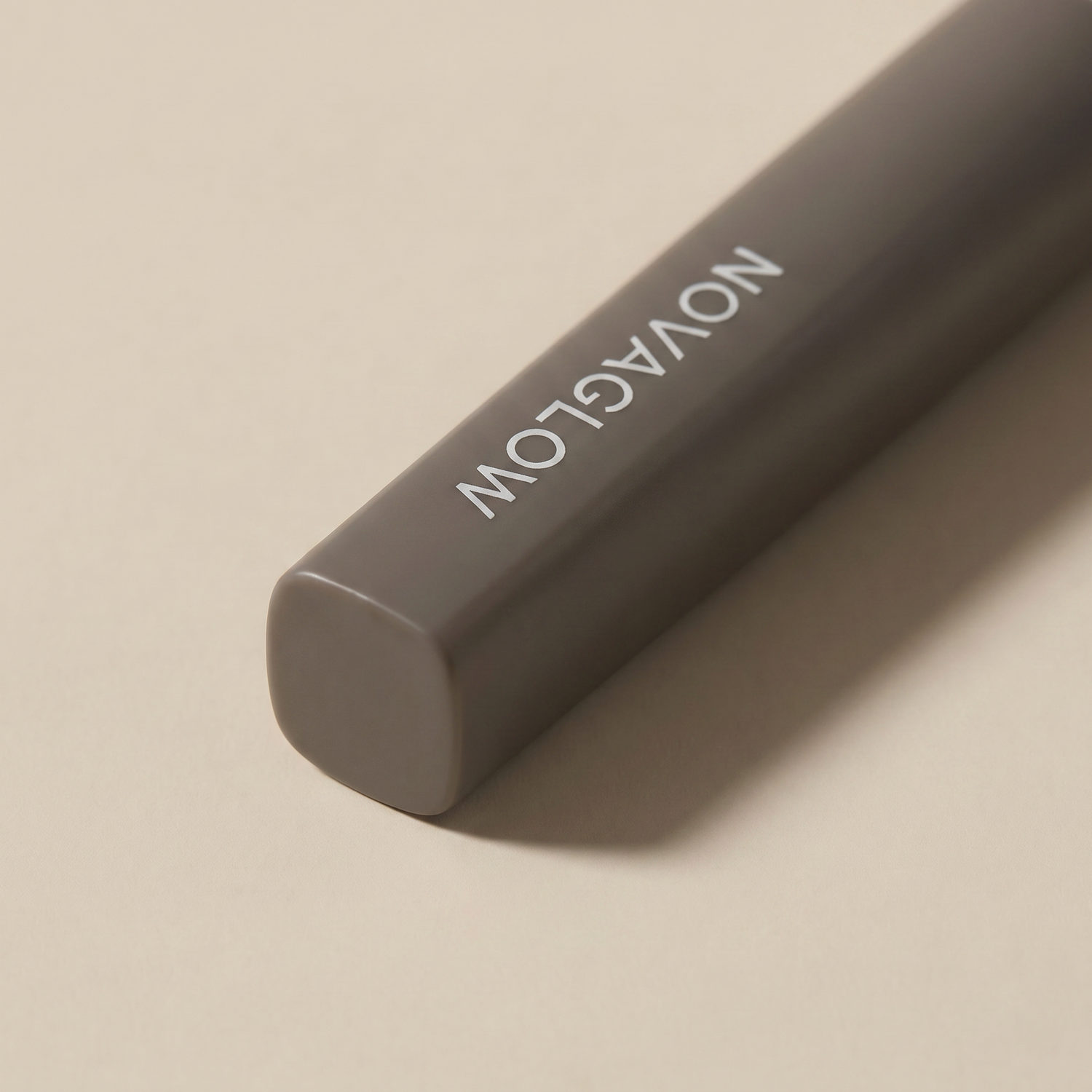 NOVAGLOW makeup brush closeup showing rounded-edge square handle